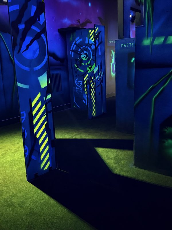 A corridor between hazard-striped bunkers with coloured floor light