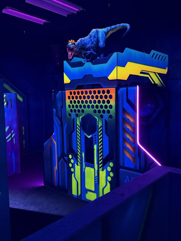 A raptor perched on a hex-panel bunker with a neon pink edge